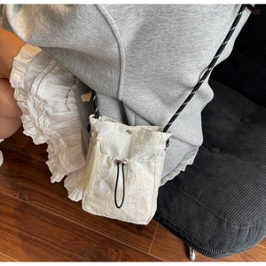 Detailed embroidery on white lace bucket bag with 3D butterfly and tassel accents
