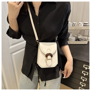 Détail d'un mini sac bandoulière blanc crème avec boucle à texture bois de style vintage