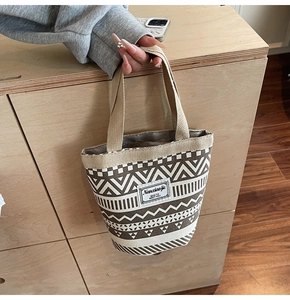 Detail of canvas bucket bag with ethnic geometric patterns and rustic handle