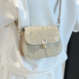 Straw saddle crossbody bag with light blue floral embroidery and golden clasp