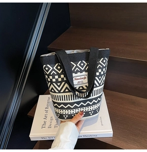 Detail of canvas tote bag with black and white geometric patterns and woven texture