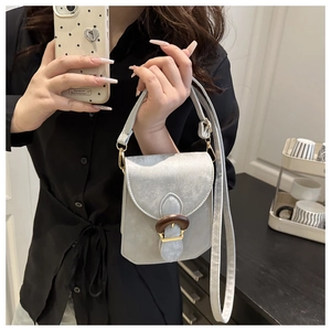 Détail du mini sac bandoulière gris argenté avec une boucle texture bois élégante