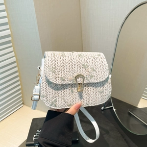 White woven saddle bag with floral embroidery and gold horseshoe buckle for summer