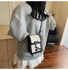 Crossbody phone bag with black and white contrast and gold brand lettering detail
