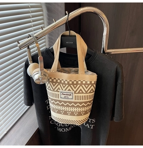 Detail of ethnic canvas bucket bag with brown geometric print and woven logo tag