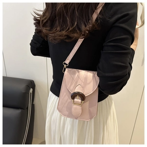 Détail d'un sac bandoulière rose clair en cuir grainé avec boucle anneau en bois foncé