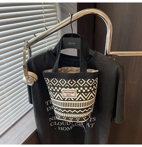 Detail of canvas bucket bag with geometric bohemian patterns on a black background