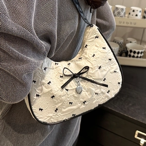Sac hobo blanc à motifs nœuds noirs avec un pendentif en métal argenté en forme de cœur