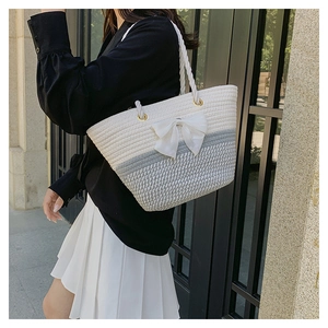 Detail of hand-woven cotton tote bag with gray-white contrast and a large satin bow
