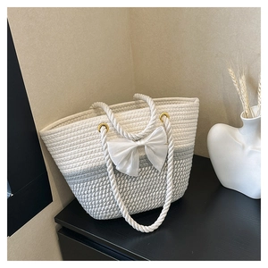 Detail of hand-woven tote bag featuring cream white contrast and large chiffon bow