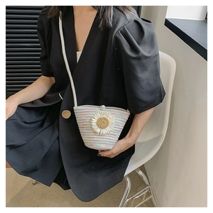 Détail du sac tissé à fleurs de marguerite avec bouton perle sur un blazer noir