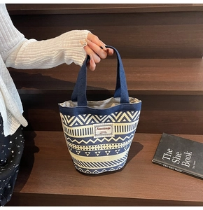 Detailed shot of ethnic canvas bucket bag featuring geometric patterns on wooden steps