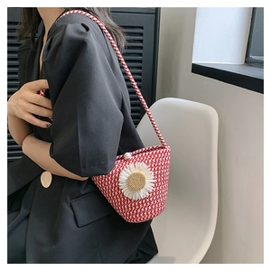 Détail du sac bandoulière tressé rouge et blanc avec marguerite et bandoulière corde