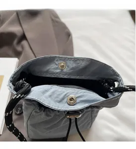 Nahaufnahme der hellblauen Nylontasche mit Kordelzug und silberner Magnetschnalle