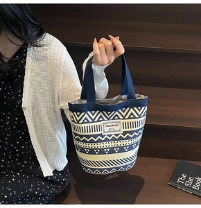 Detail view of ethnic canvas tote bag with blue geometric pattern and branded label