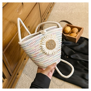 Détail d'un sac seau tissé main avec décoration de marguerite et fermoir perle