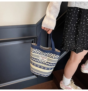 Detail of canvas bucket bag with ethnic geometric patterns and stylish logo patch
