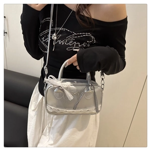Dettaglio della mini borsa bowling argento con fiocco in pizzo bianco e nastro a scacchi