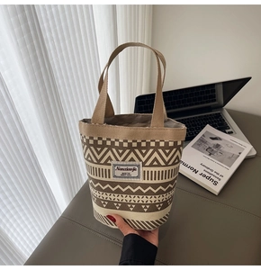 Detail of bohemian canvas bucket bag with geometric patterns and woven handles