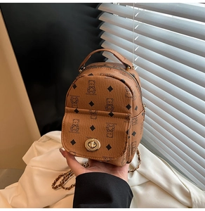 Détail d'un mini sac à dos en cuir PU marron avec motif ours et bandoulière dorée