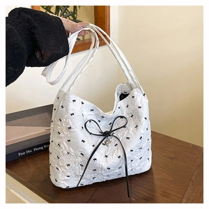 Detailansicht der weißen Bubble-Tote-Bag mit schwarzen Schleifen und Herz-Anhängern