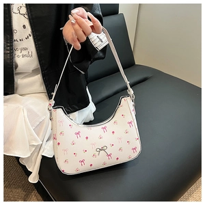 Close-up of floral print crescent bag with pink bows and silver butterfly buckle detail
