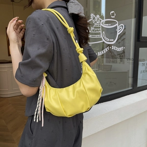 Bright yellow pleated crescent underarm bag with knotted strap and fashion embossing