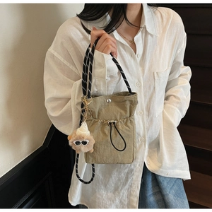 Details der khakifarbene Nylon-Zugbeuteltasche mit gestreiftem Gurt und Anhänger