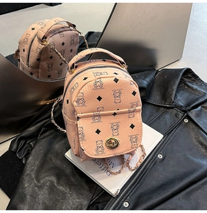 Détail d'un mini sac à dos rose avec motif d'ours et chaîne dorée élégante