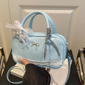 Borsa bowling azzurra con pizzo e fiocco, mostrata in una posa a mano molto elegante