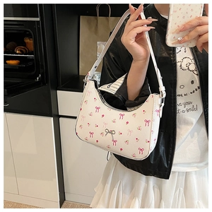 Detail of floral underarm bag with pink bows and silver hardware on a white base