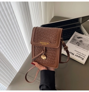 Close-up of brown quilted faux leather phone bag with gold charm and fine stitching