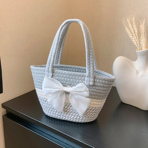 Handwoven beach tote with gray-white stripes and a large white decorative silk bow