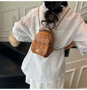 Détail d'un mini sac à dos marron avec imprimé ours, fermoir doré et bandoulière
