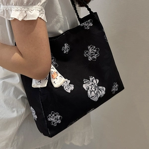 Floral print black canvas tote bag with shoulder rope straps and white scarf accessory