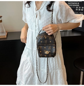 Détail du mini sac à dos marron imprimé avec fermoir doré et bandoulière chaîne