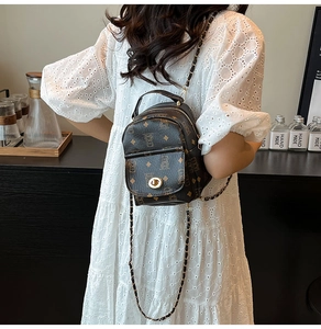 Mini sac à dos marron avec imprimé ours et bandoulière chaîne porté sur robe en dentelle
