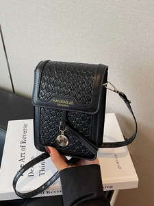 Women's black quilted crossbody phone bag with gold logo and round metal pendant charm