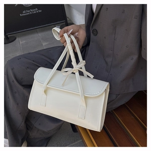 Vue détaillée d'un sac à main rectangulaire en cuir blanc avec un nœud élégant sur la poignée