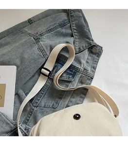 Détail du sac bandoulière en nylon beige avec sangle réglable et boucle en plastique noir