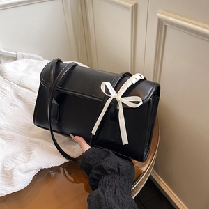Sac bandoulière minimaliste en similicuir noir pour femme avec un nœud blanc