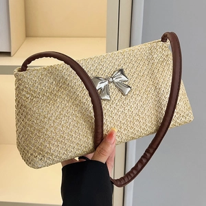 Minimalist straw shoulder bag with metallic bow and brown leather straps in cream white