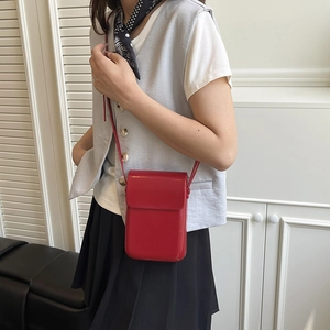 Chic red faux leather crossbody phone bag shown on a model in a minimalist setting