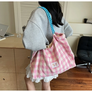 Détail du sac cabas en toile à carreaux rose avec poignées en corde bleue et étiquette