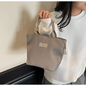 Silver nylon crossbody bag showing the fashion label detail and water-resistant fabric