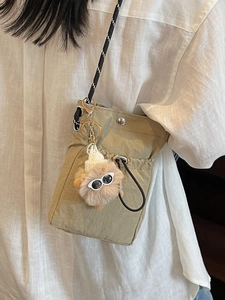 Mini-Umhängetasche aus khakifarbenem Nylon mit Kordelzug und süßem Plüschmonster-Anhänger