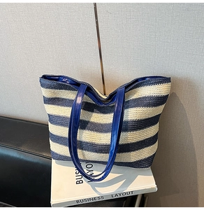 Close-up of blue and white striped woven tote bag with premium leather handles