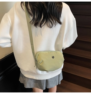 Détail du sac bandoulière en nylon vert clair avec double fermeture et sangle réglable