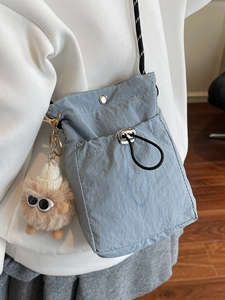 Hellblaue Mini-Umhängetasche aus Nylon mit Kordelzug und süßem Plüsch-Monsteranhänger