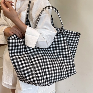 Minimalist black and white checkered canvas tote bag for women shown as a side-view shoulder bag